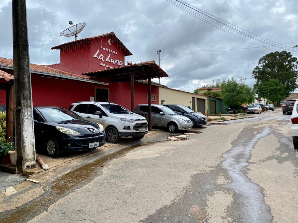 Carros pequenos parados na calçada da pousada. 