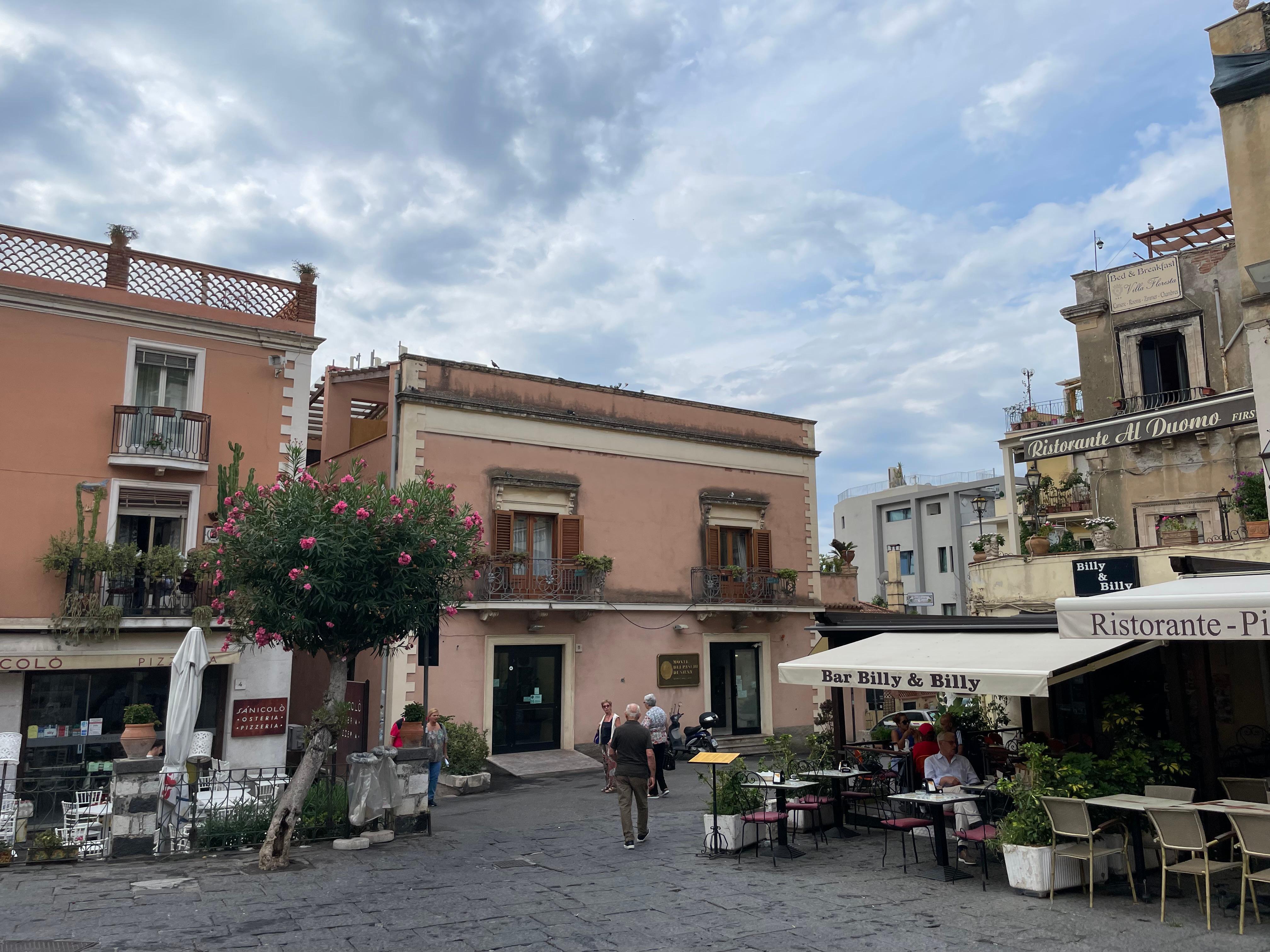 View from Piazza Duomo, rooms in nondescript blocky bldg in center, Osteria Sanicolo on left