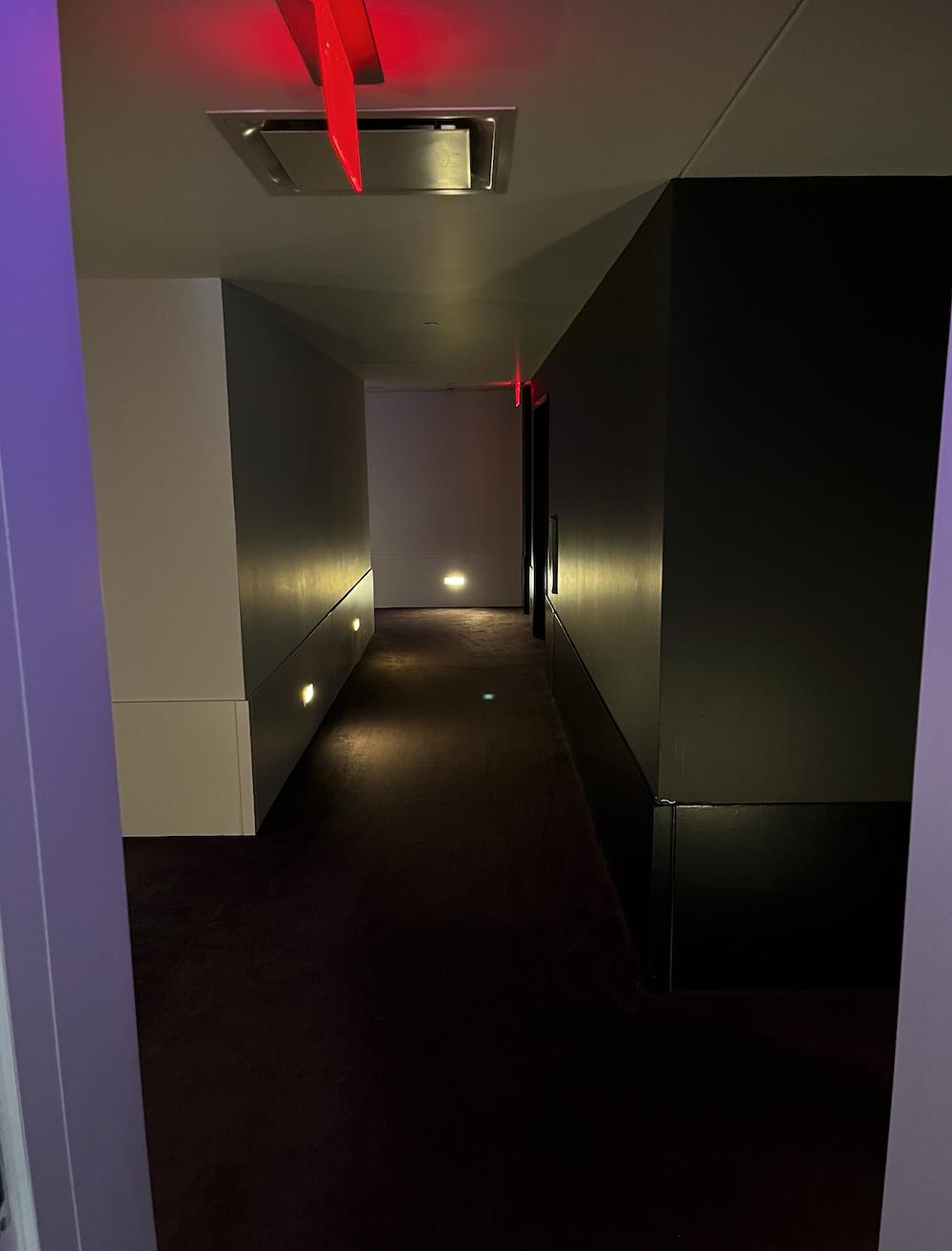 Hallways are dark. Doors lit in purple. Very creepy.