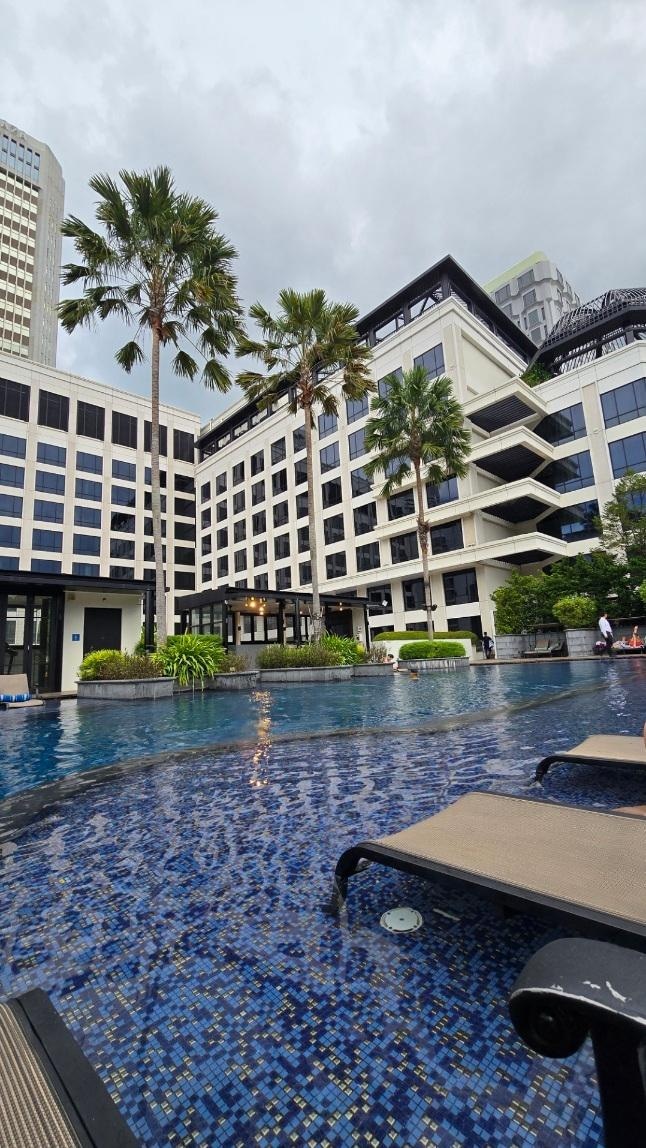 Pool with hotel in background.