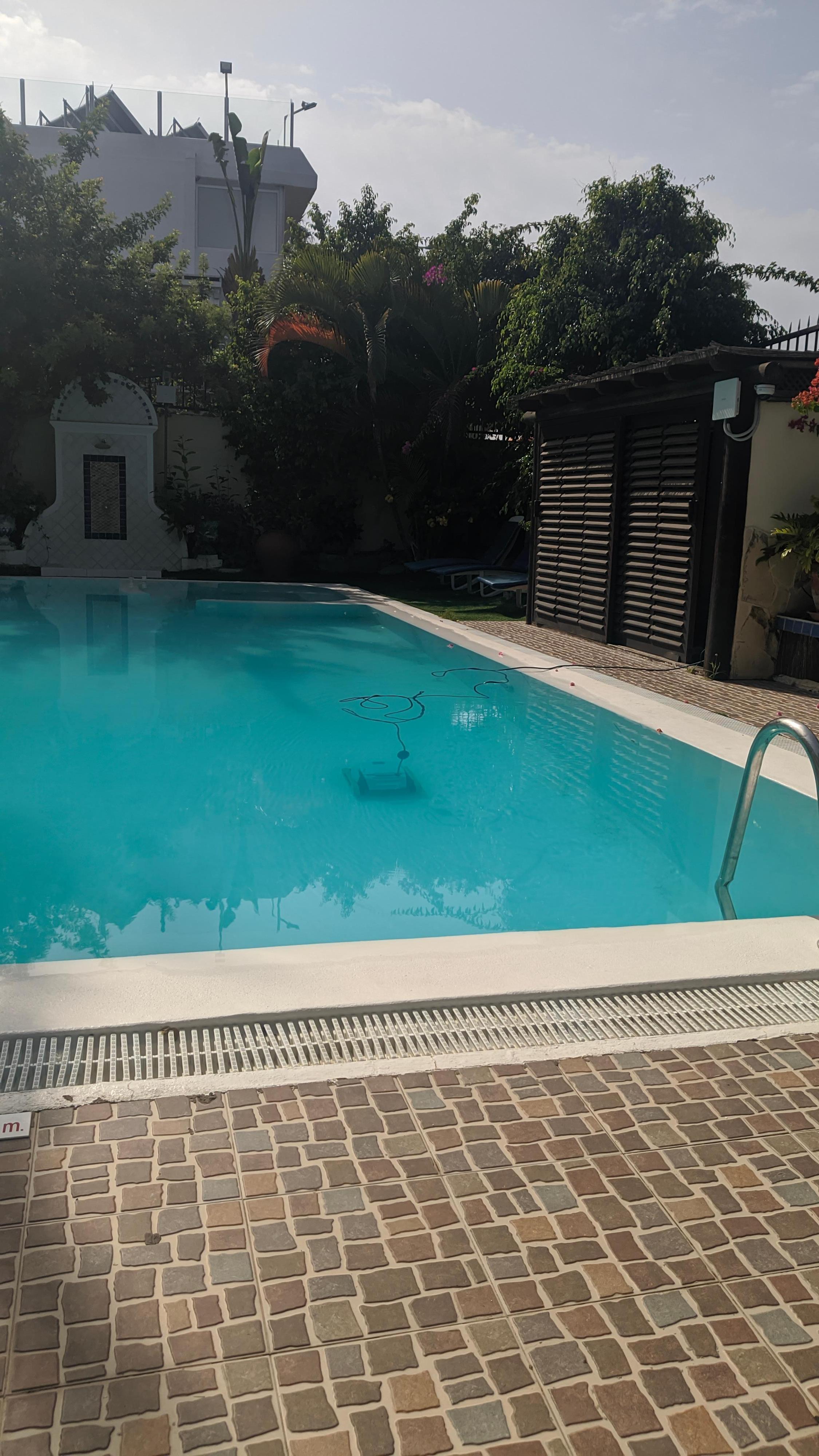 Piscina con aparato de limpieza eléctrico dentro. 