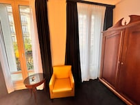 Habitación con dos ventanas,cortinas que no pasa la luz ,postigos de hierro por fuera .