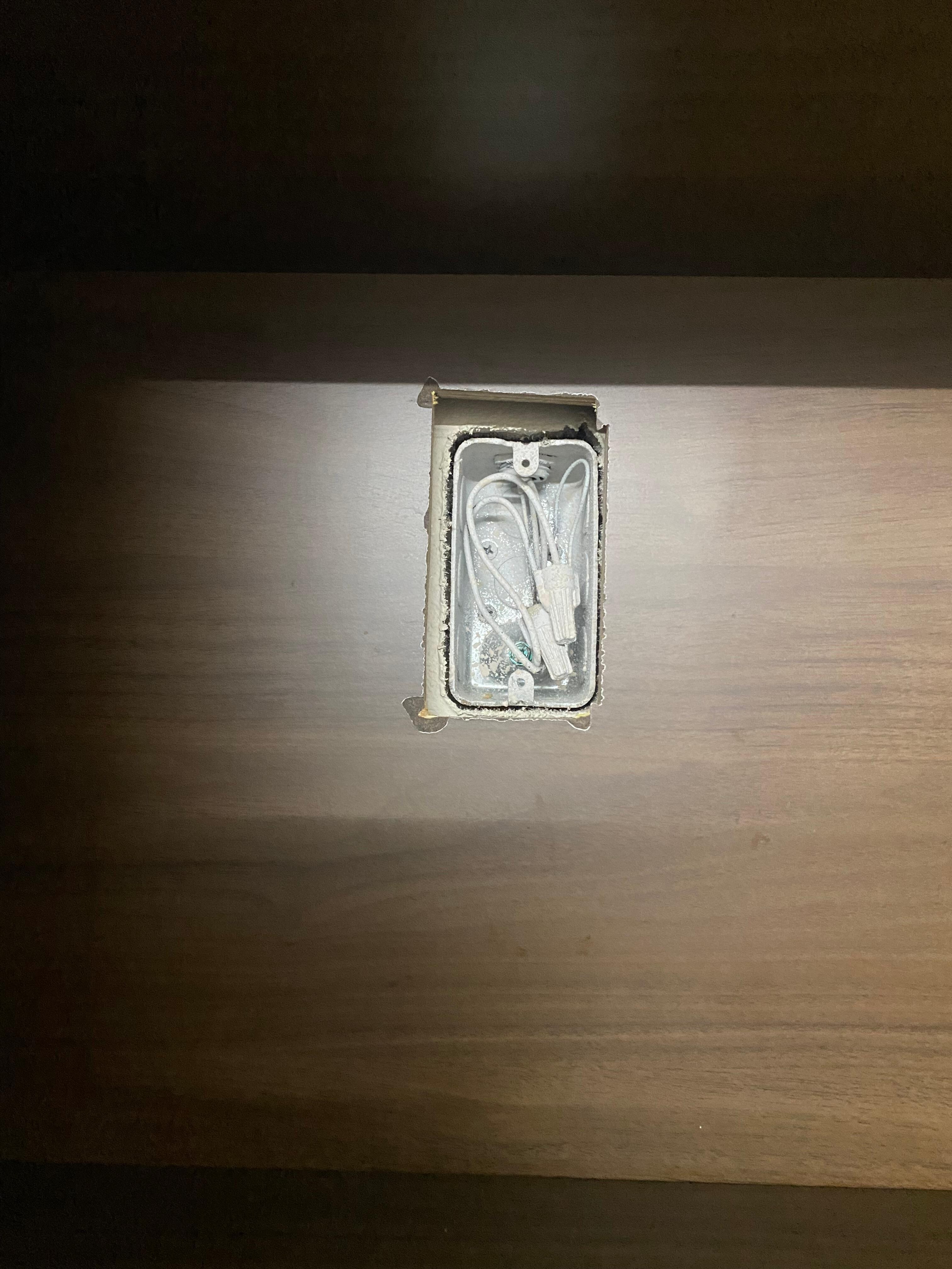 Open electrical wires in kitchenette cabinet.