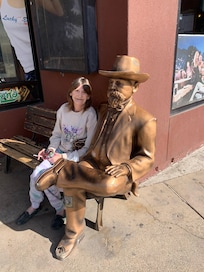 A bench with statue near Dotties casino