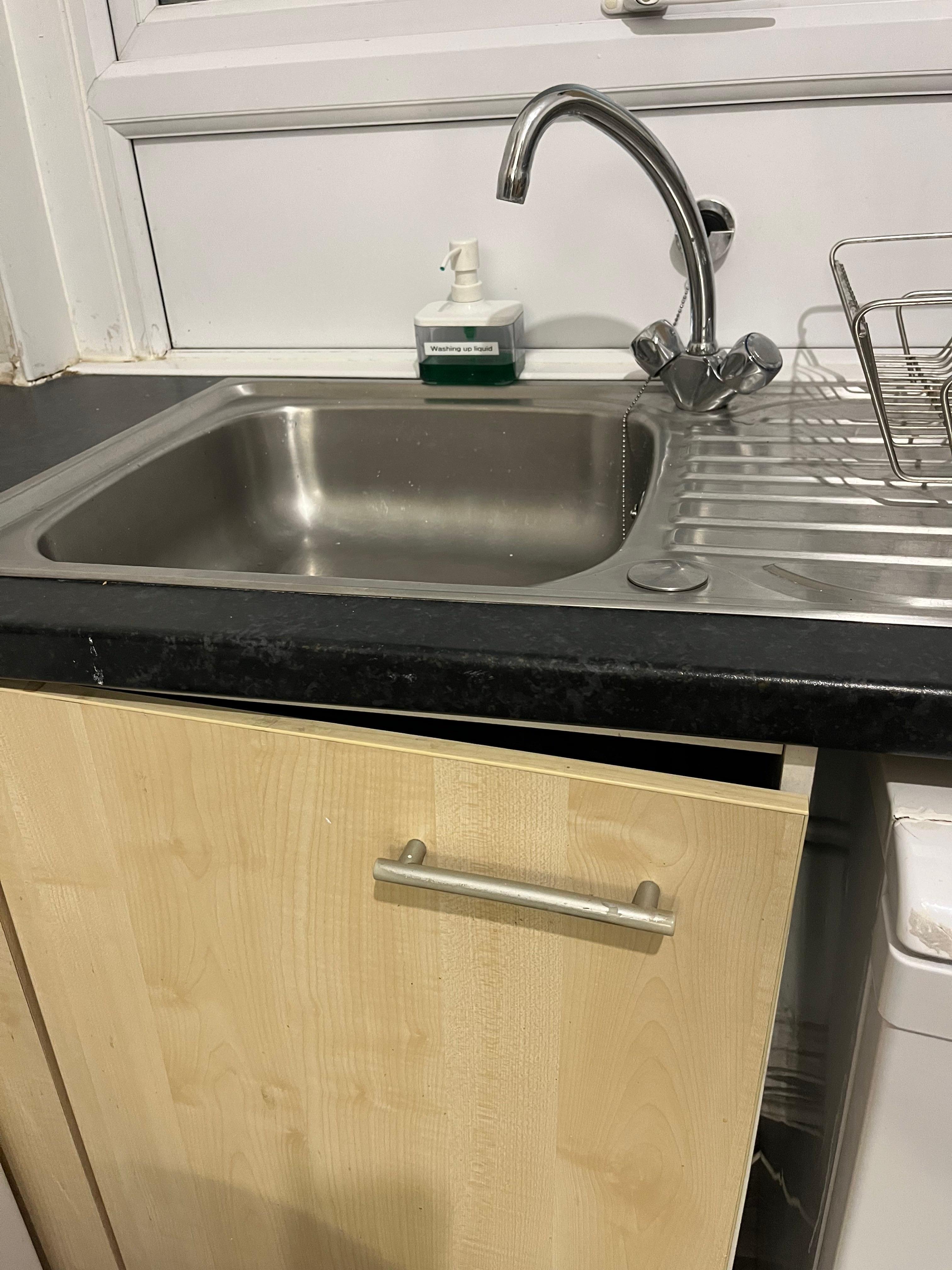 Broken cupboard and dirty sink