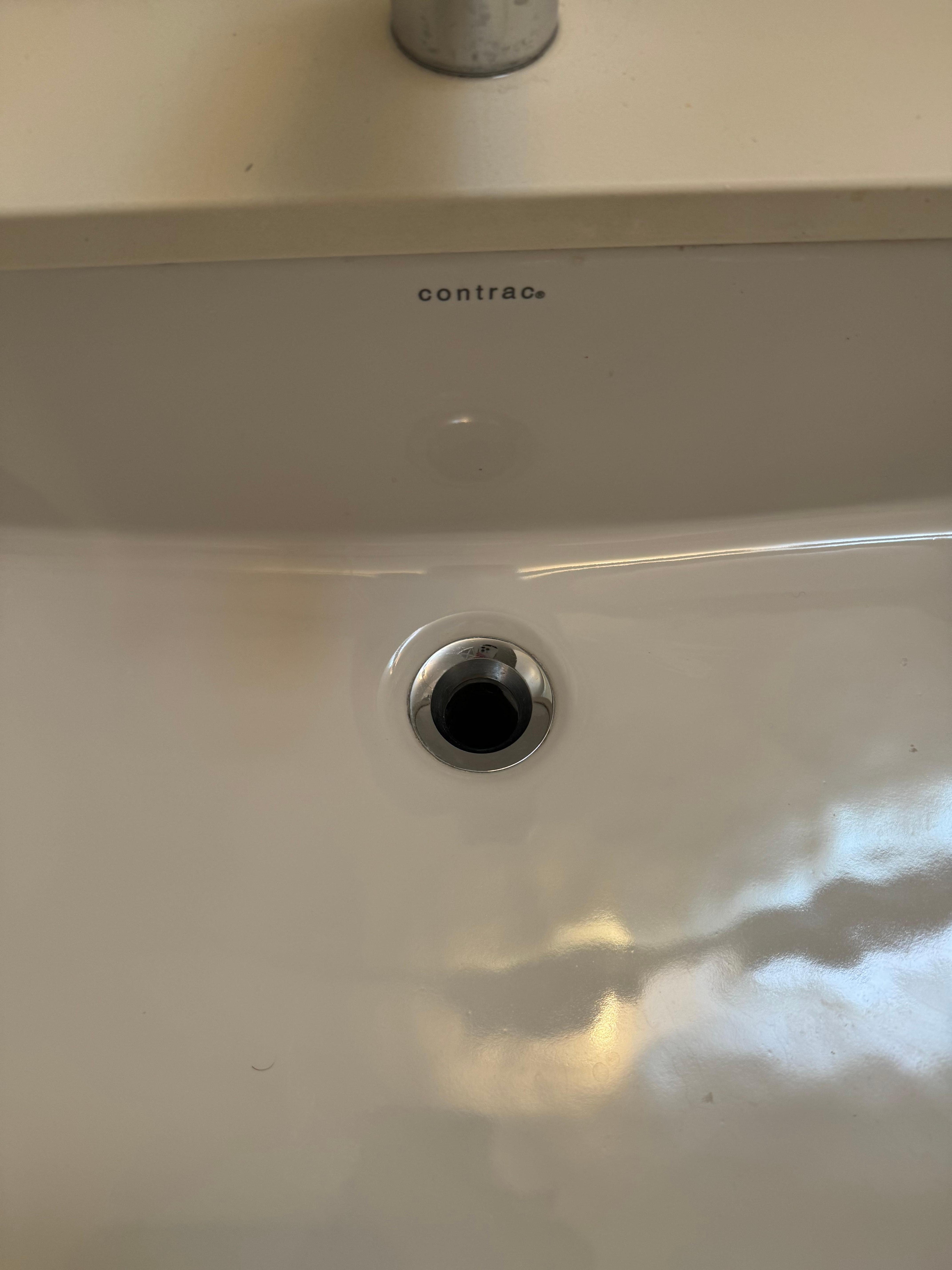 the drain in the bathroom sink is broken and sitting on the counter when you enter