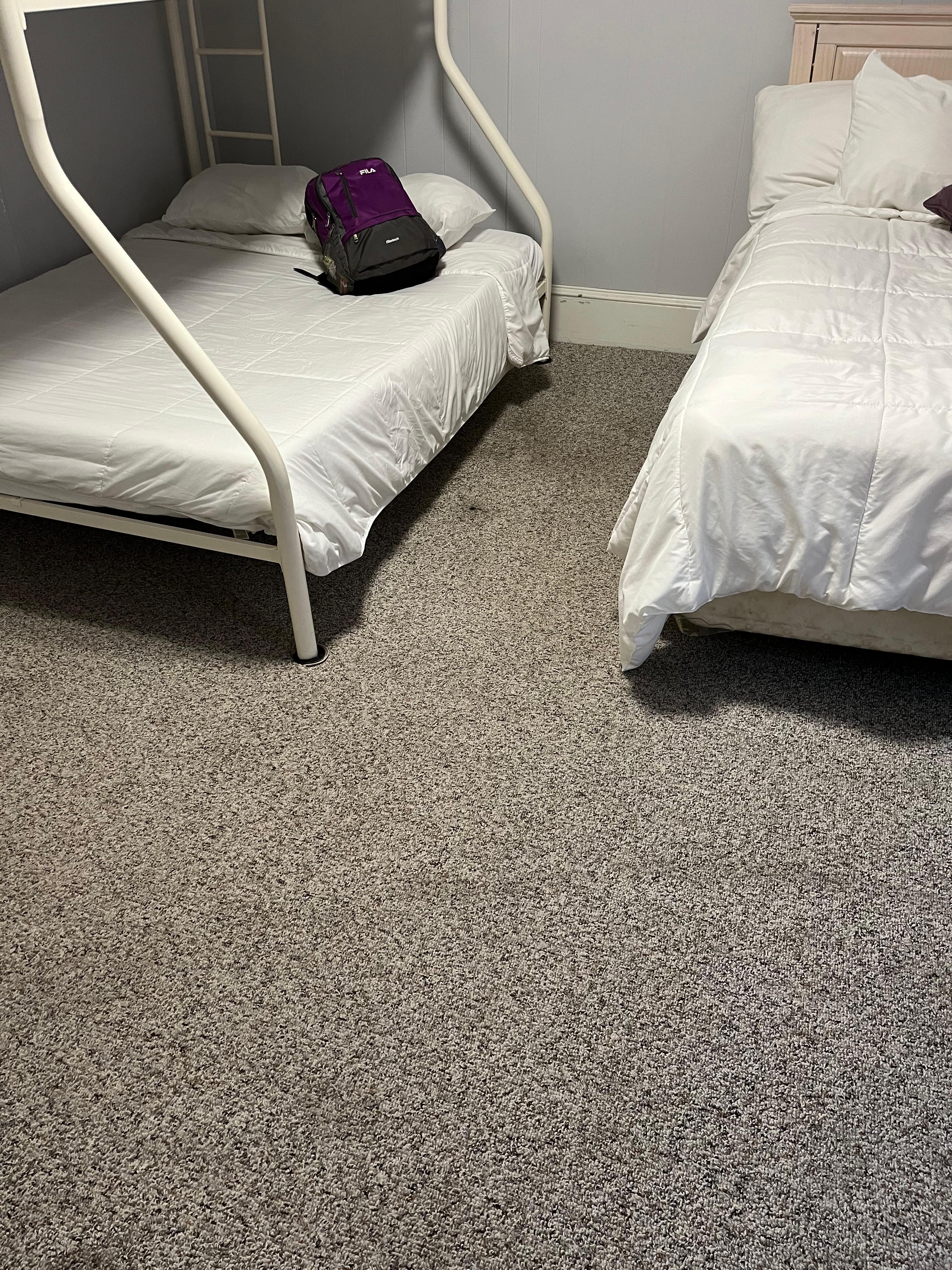 Really discolored Carpet and tilted floor In the second bedroom.