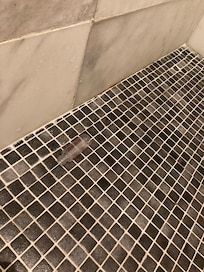 Old and emptly shampoo bottle on the floor from previous guest