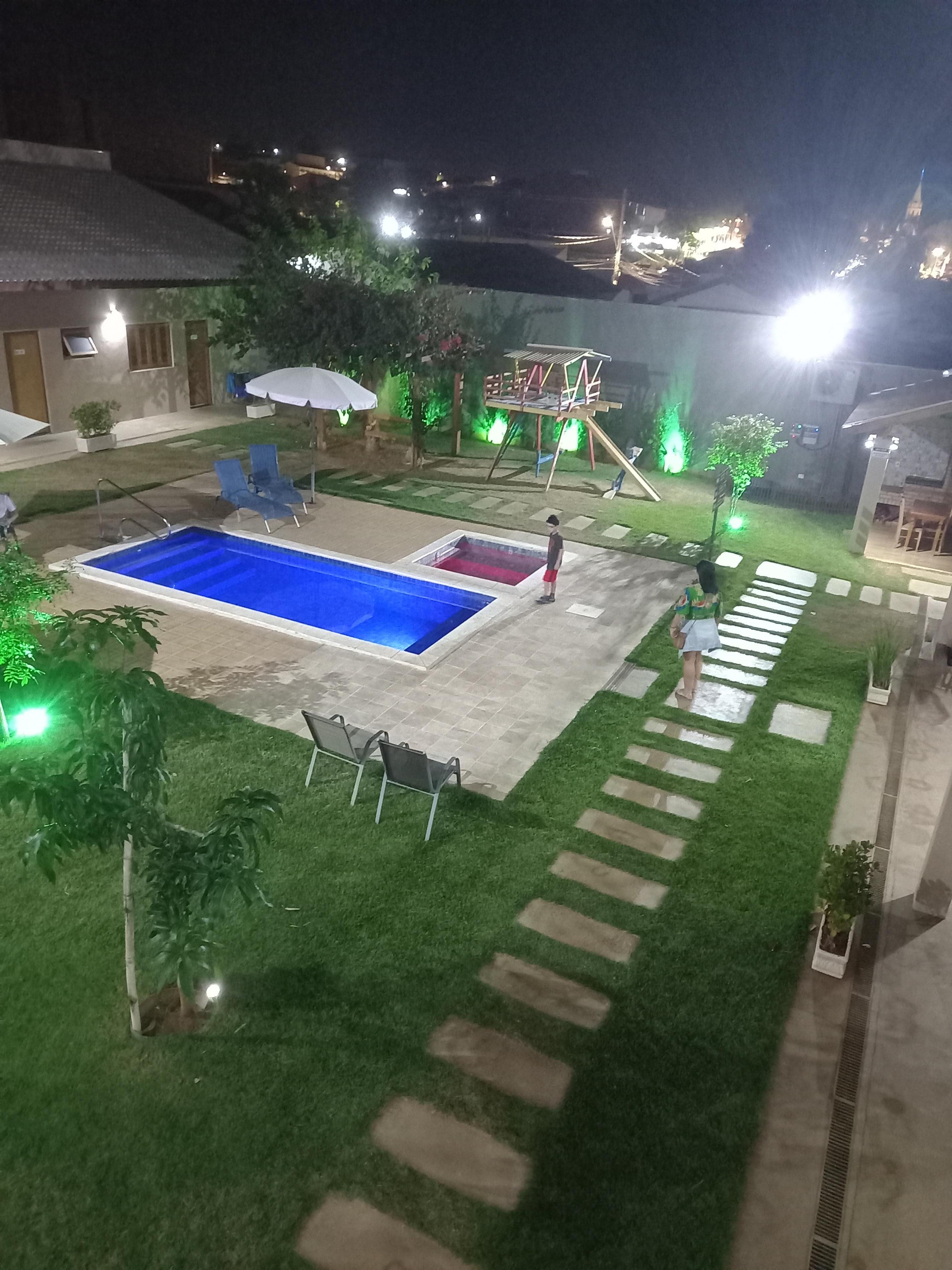 Área externa com piscinas e casa de brincar