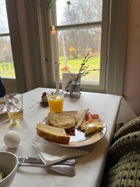 Mysigt frukostrum med fönster mot trädgården.