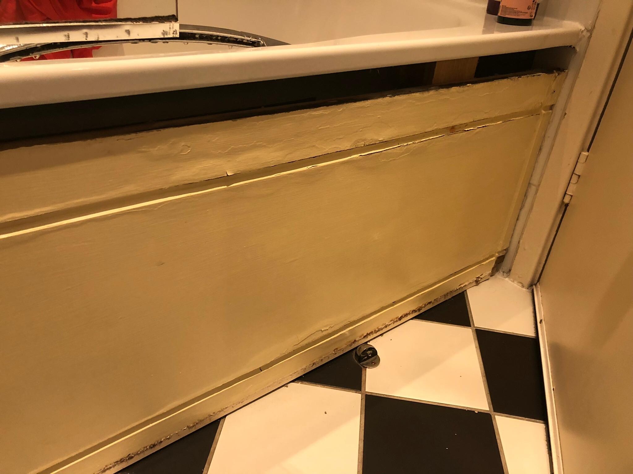 Badly fitted bath panel in poor state.