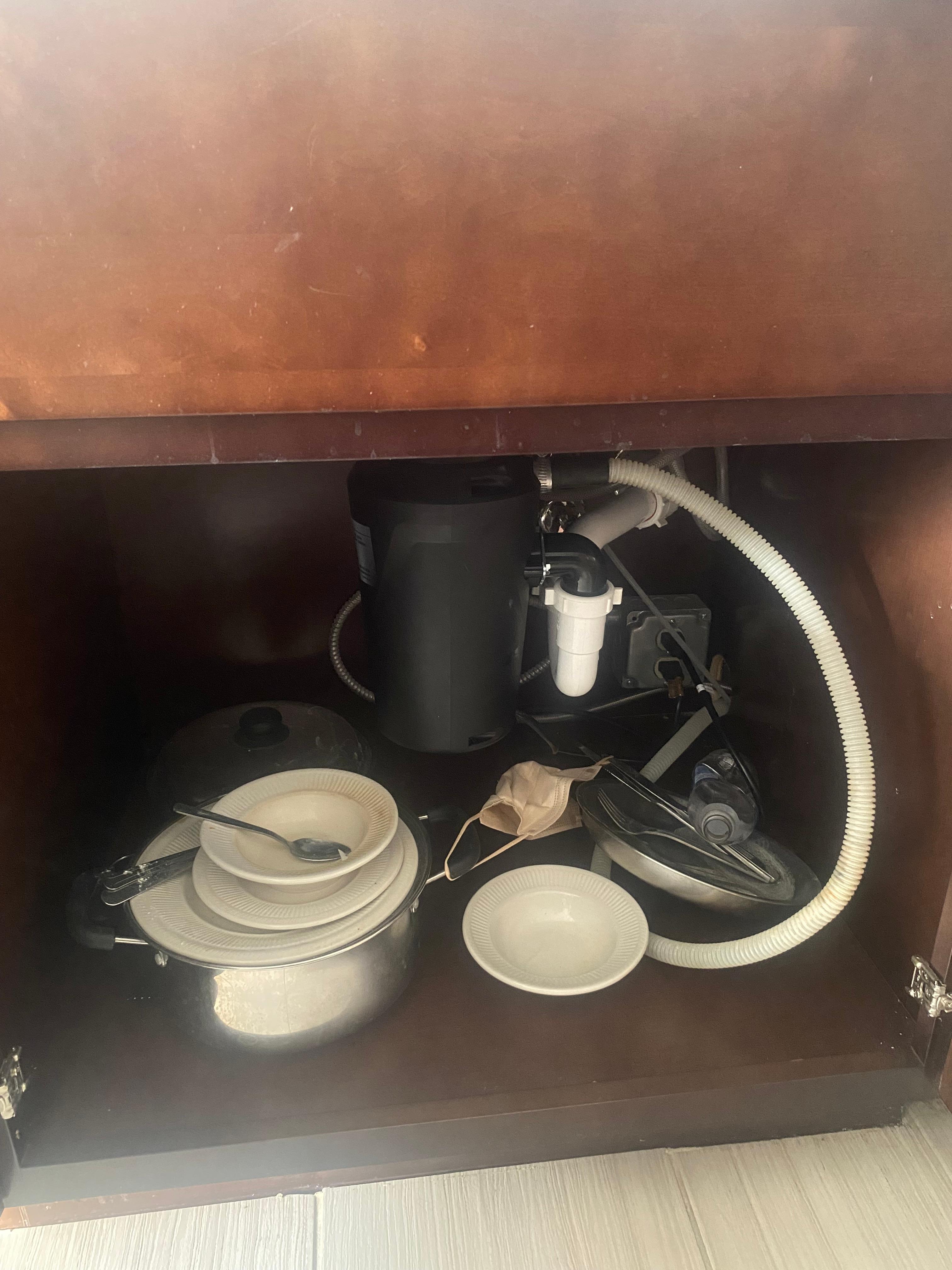 Dirty dishes hidden under kitchen sink 