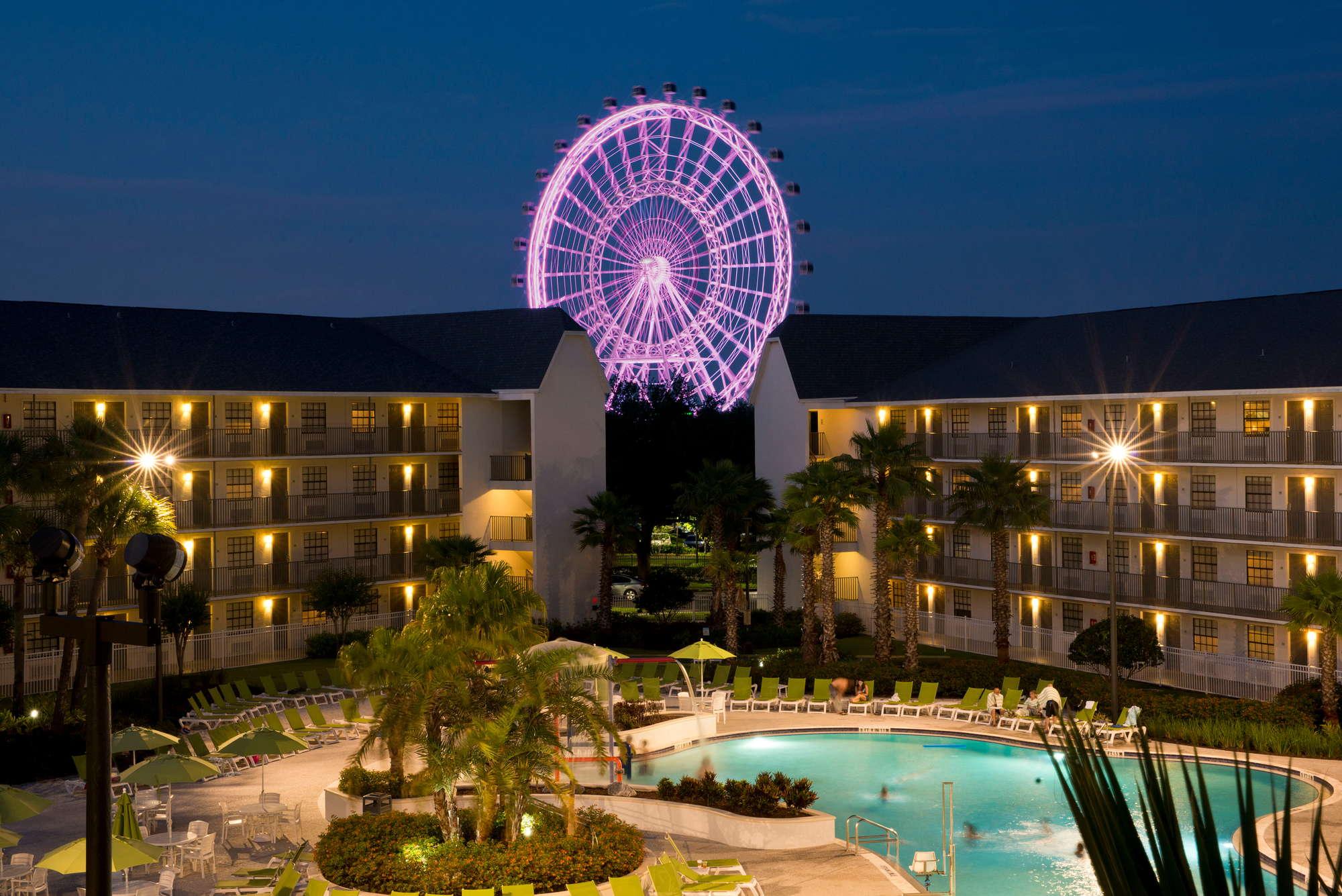 The court yard of hotel with Icon Park Ferris Wheel in the background.