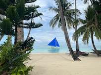 Sailing boat going by immediately in front of Boracay Beach houses. Not a soul around. The photo doesn’t look real but it is.