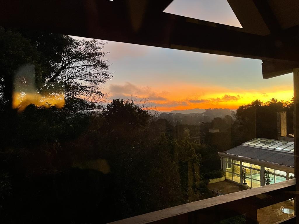 Pôr do sol visto do nosso quarto com a vista da piscina coberta na parte de baixo à direita