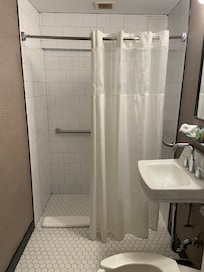 Shower curtain. No rim on the floor so the whole room gets wet.