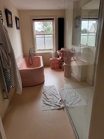 A pink bathroom with sash window