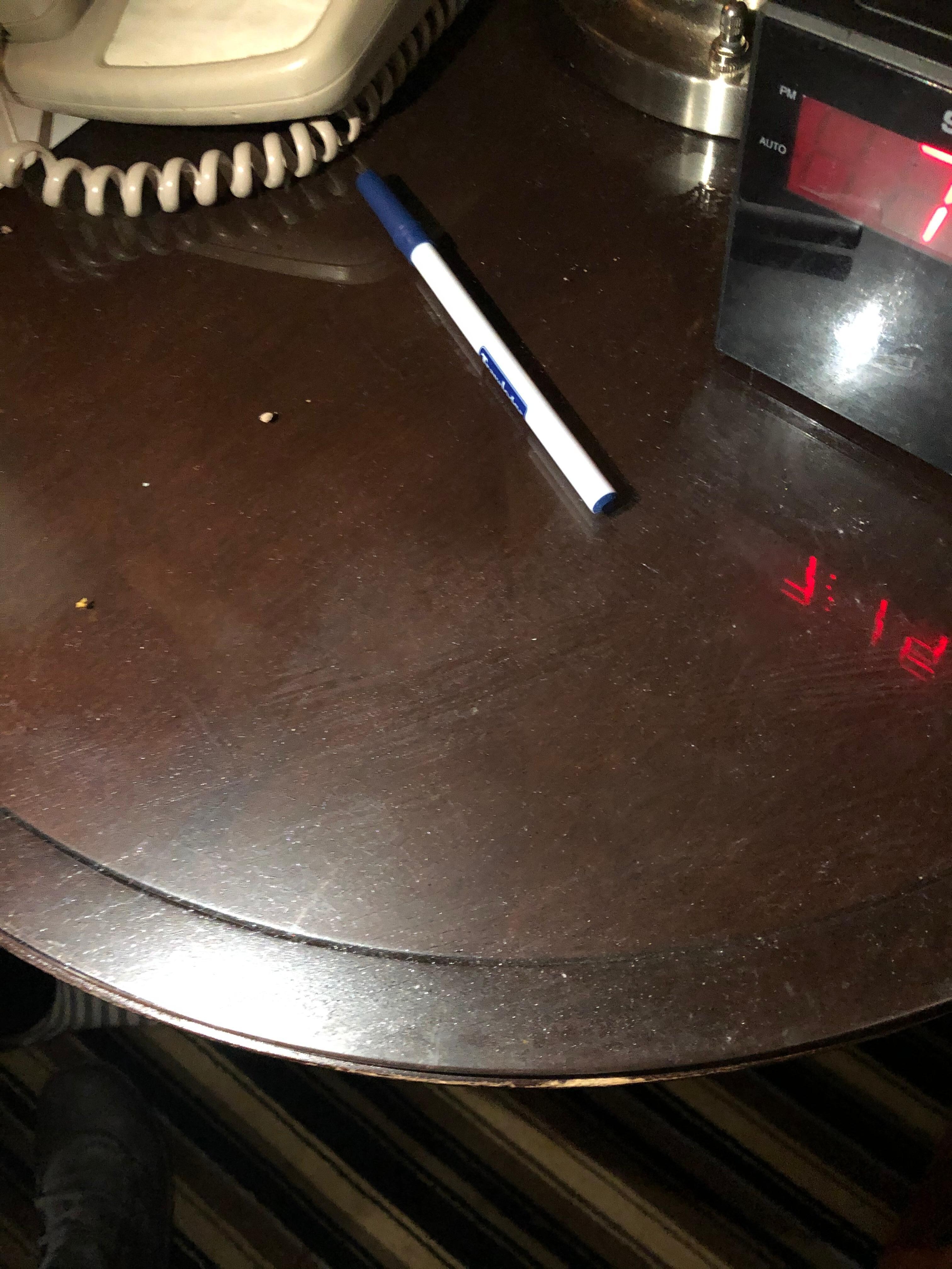 Mesa de noche , sucia y donde aparenta haberse derramado una bebida , ademas de sucia esta pegajosa