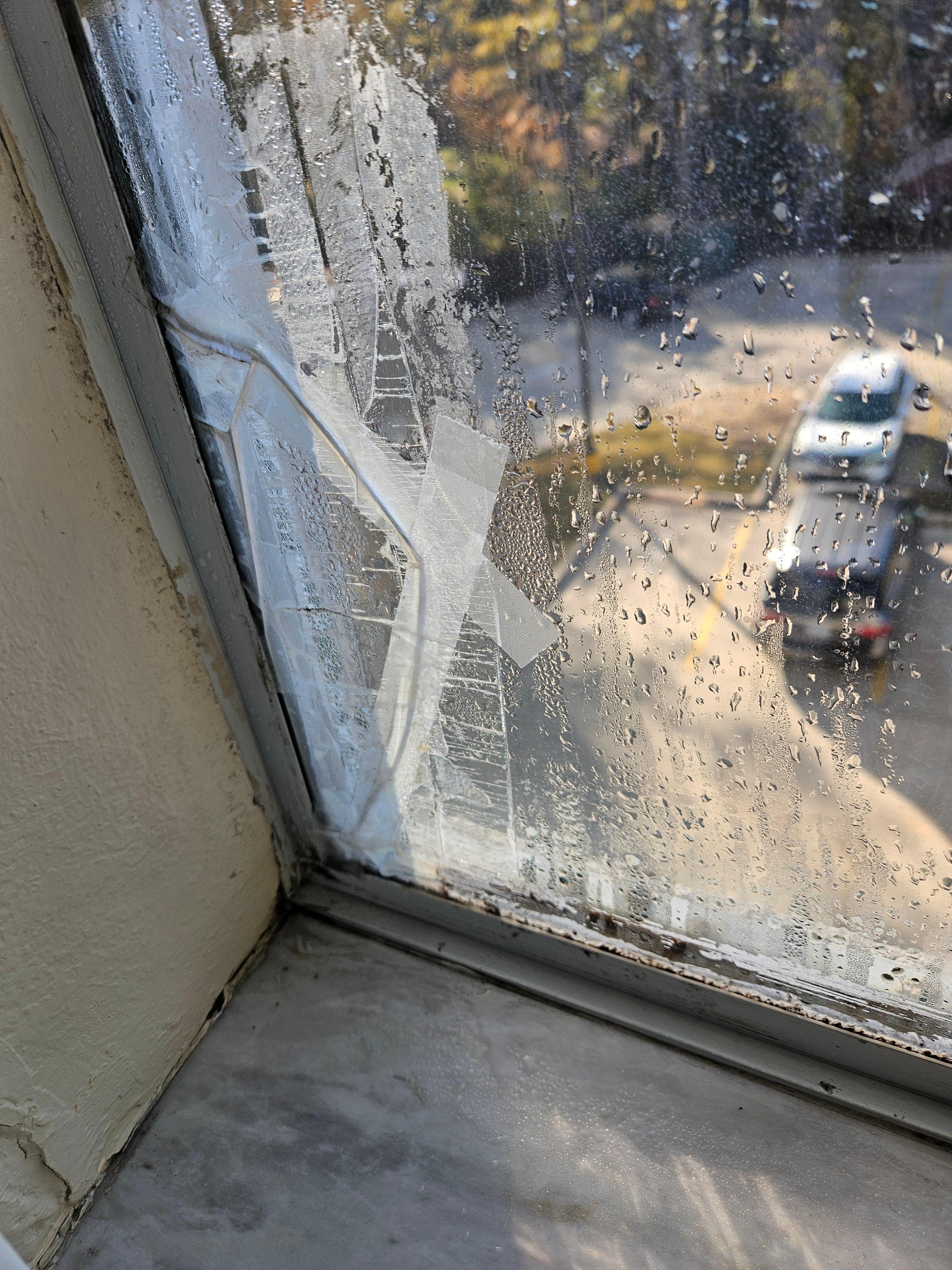 Broken window with scotch tape as repair.