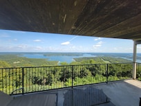 Private balcony with multiple chairs and tables.