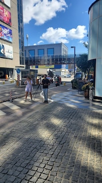 Aan de voorzijde. Ze zijn foto gek. Heb je hier niet in Nederland. Lekker genieten van het terras. Overkant ook zitten. Winkel genoeg, aan de overkant.