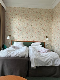 Rom med to enkeltsenger samt to stoler, bord, pult og skrivestol