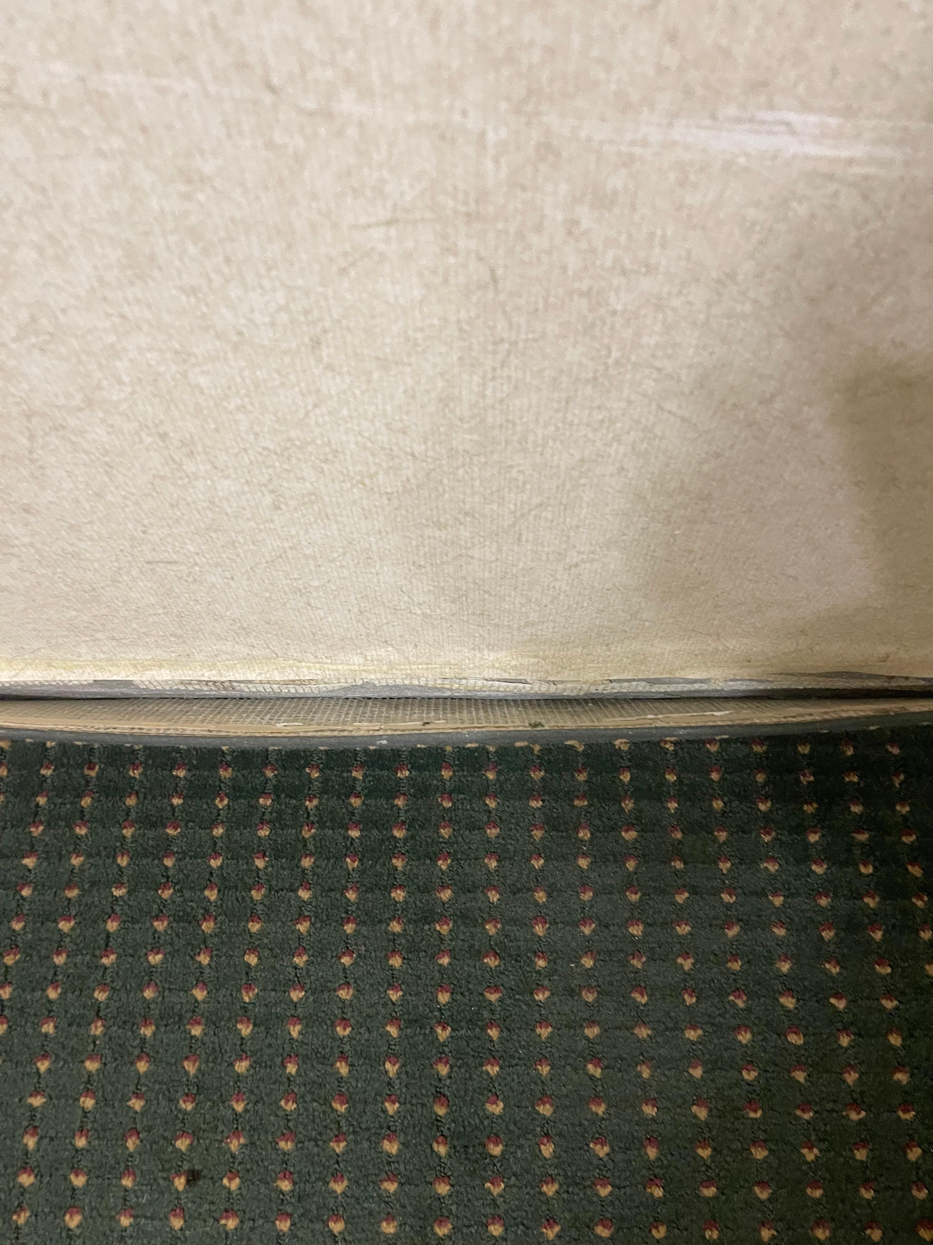 Carpet peeling away from wall