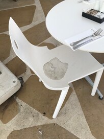 One of many stained chairs on the dining room balcony