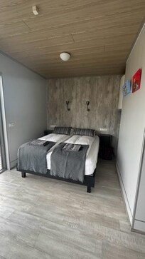 Water heater next to bed where coat hangers could be