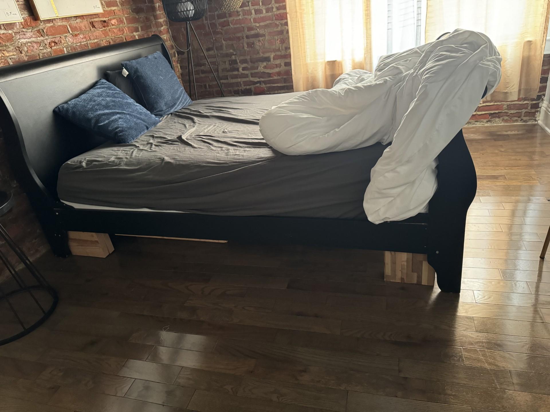 Broken bed supported by pieces of wood