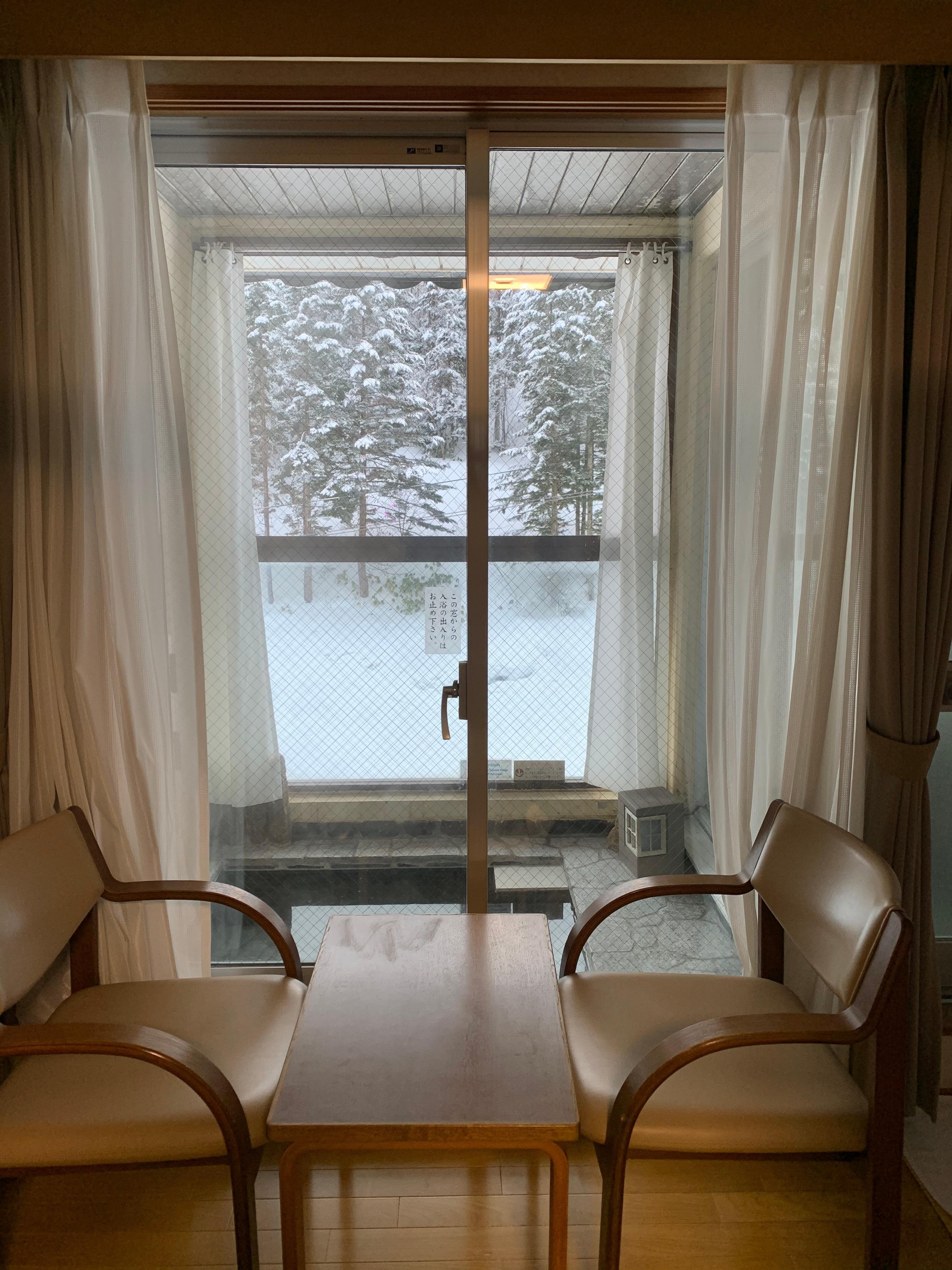 房間內一人用溫泉對住滑雪場初級滑道