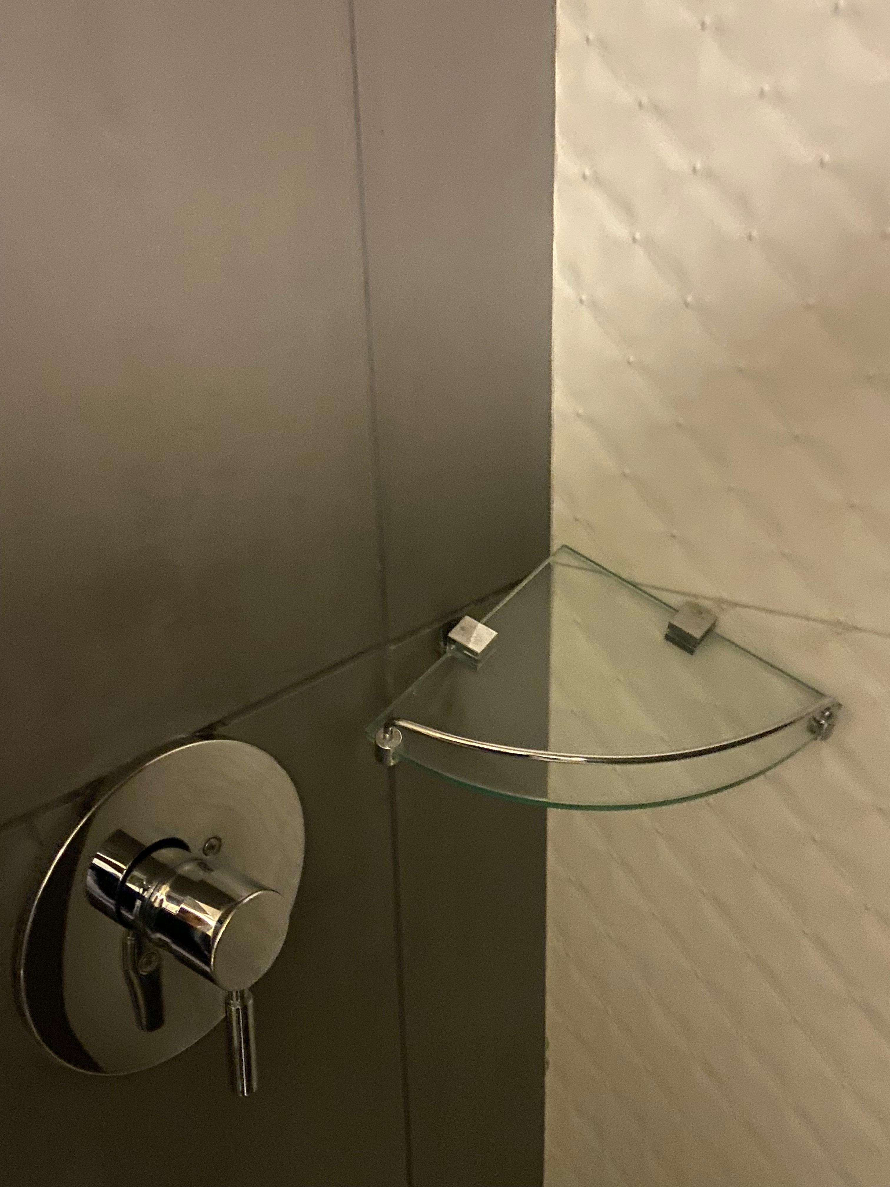 Broken shower shelf- hangs down