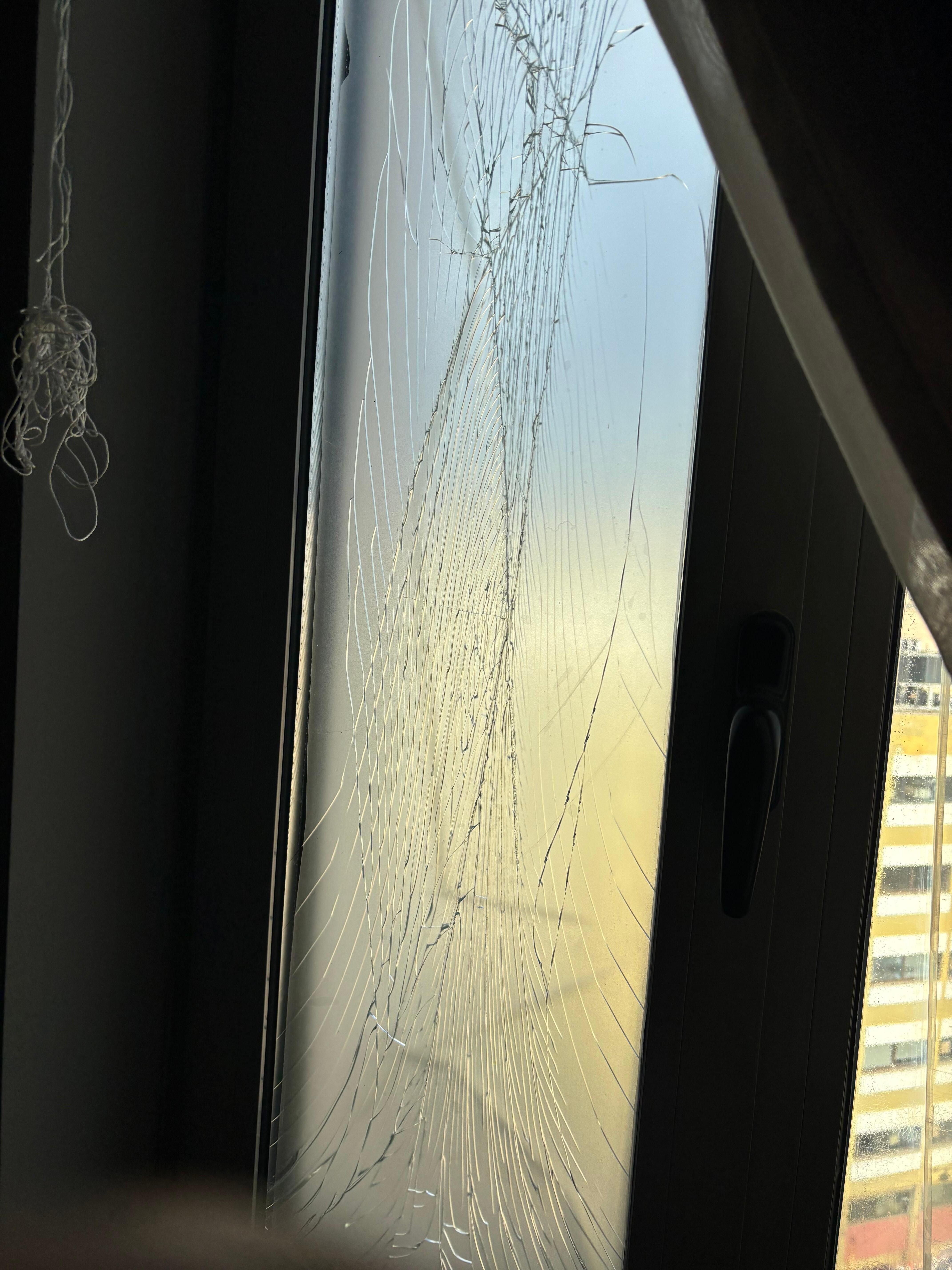 Smashed glass covered in plastic film