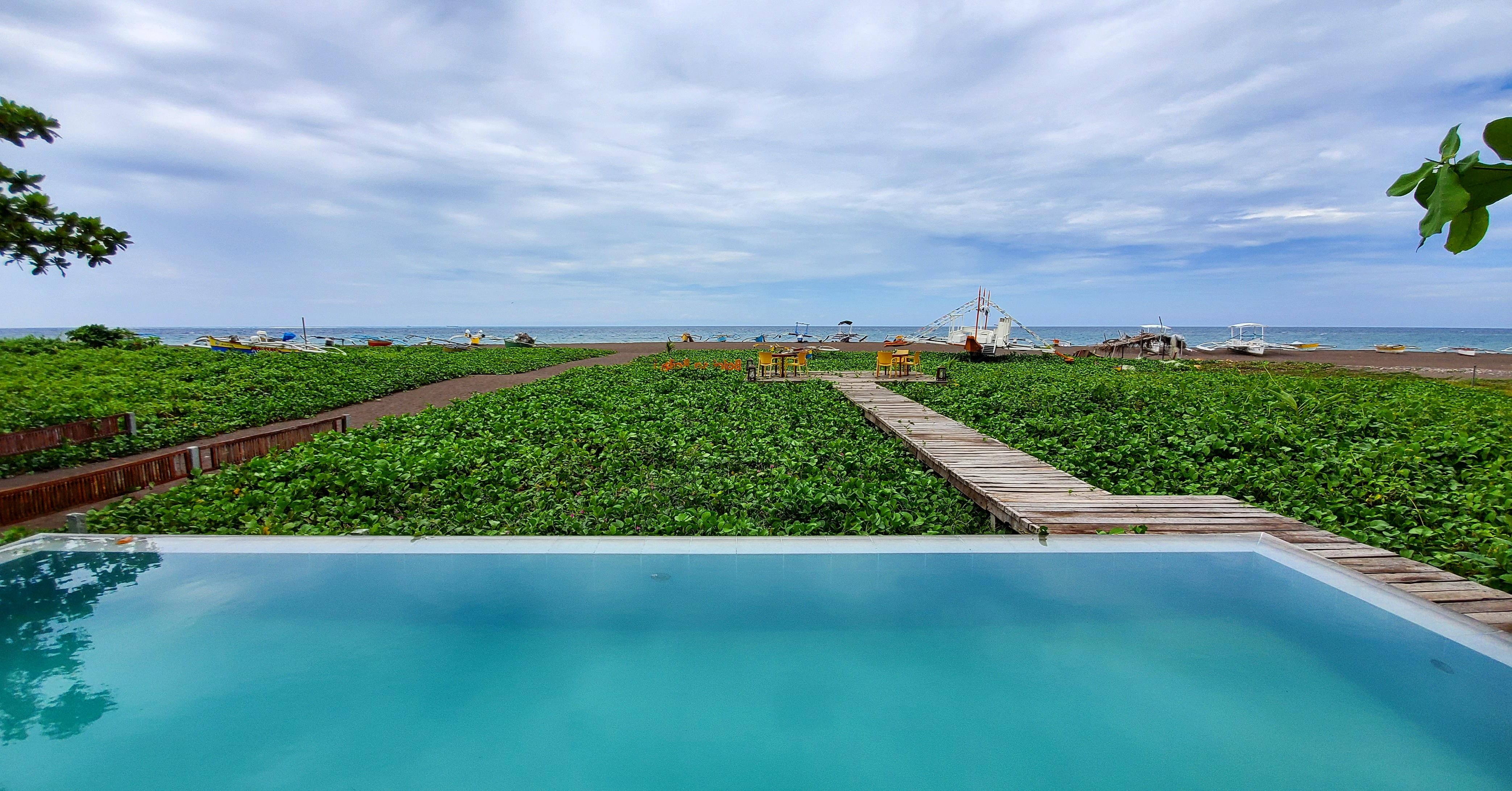 The guest pool by the bar with aq view of the beach