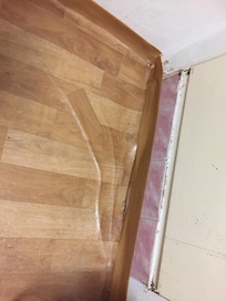 The fake wood floor was badly damaged and folding due to the puddle that formed whenever you showered.