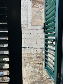 Three windows all look out directly on to stone walls.