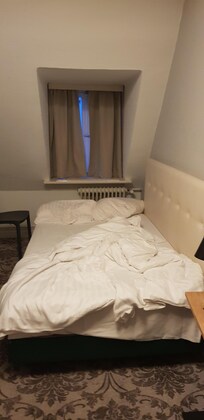 Sin cabecero, cama contra la pared, teniendo que molestar a la otra persona para salir