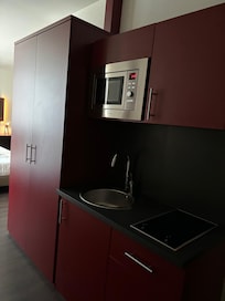 Tekøkken. Køleskabet er inde i højskabet.