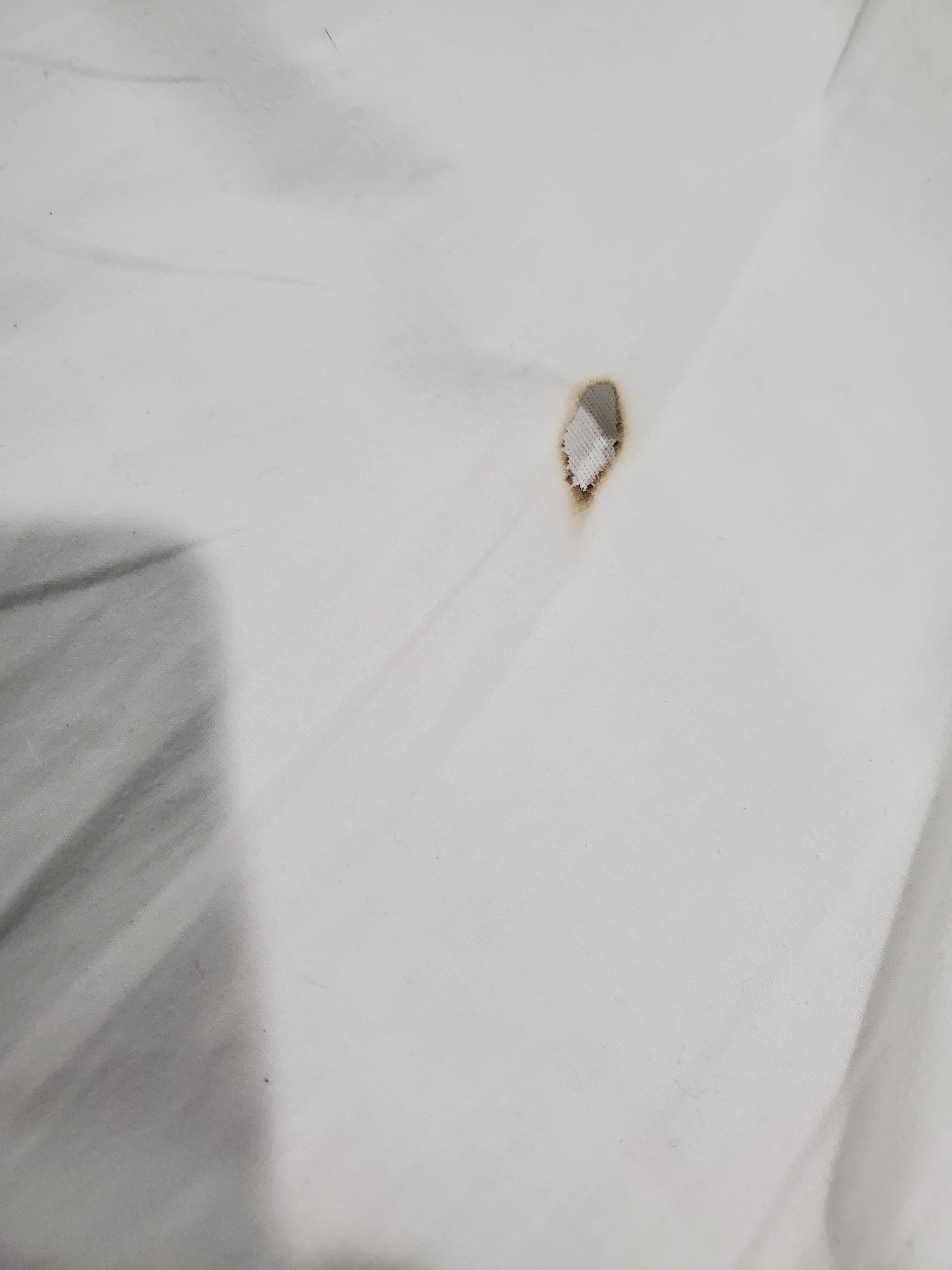 Cigarette burn in the clean sheets.
