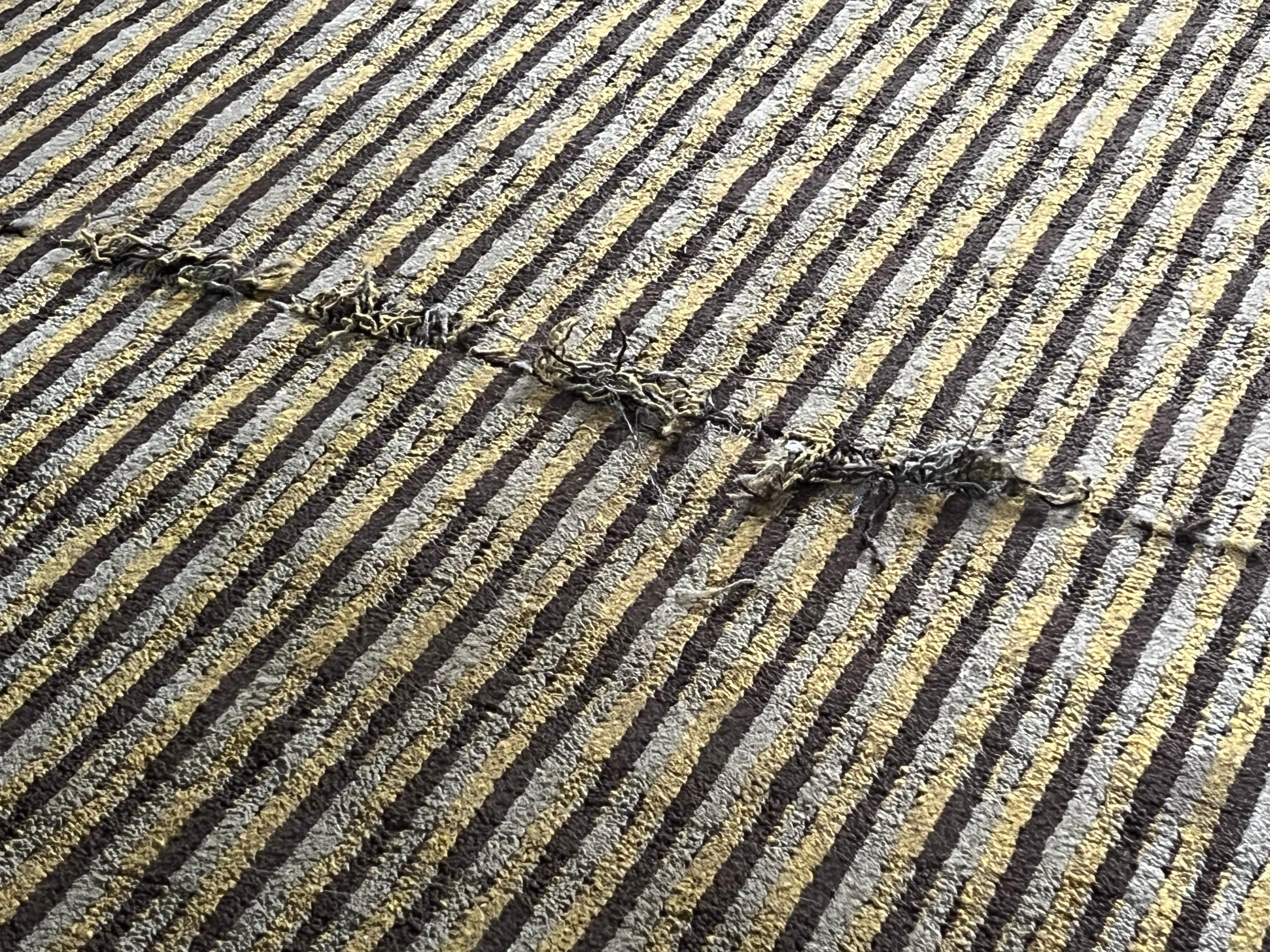 Threadbare carpet at foot of bed