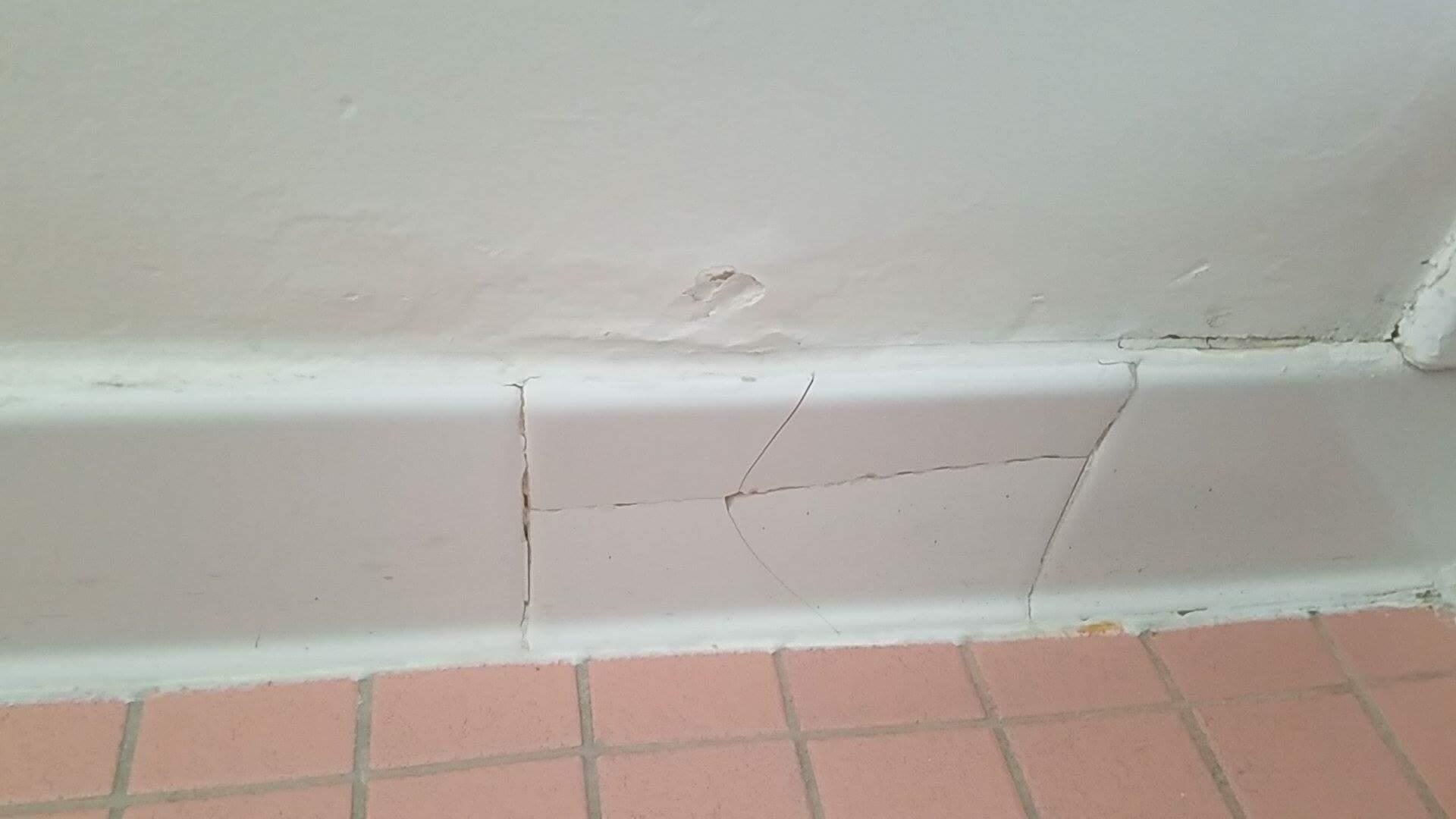Cracked tiles and light switch covers.
