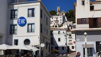 Hotel and beach front cafe with old town of Altea on hill behind with pretty church