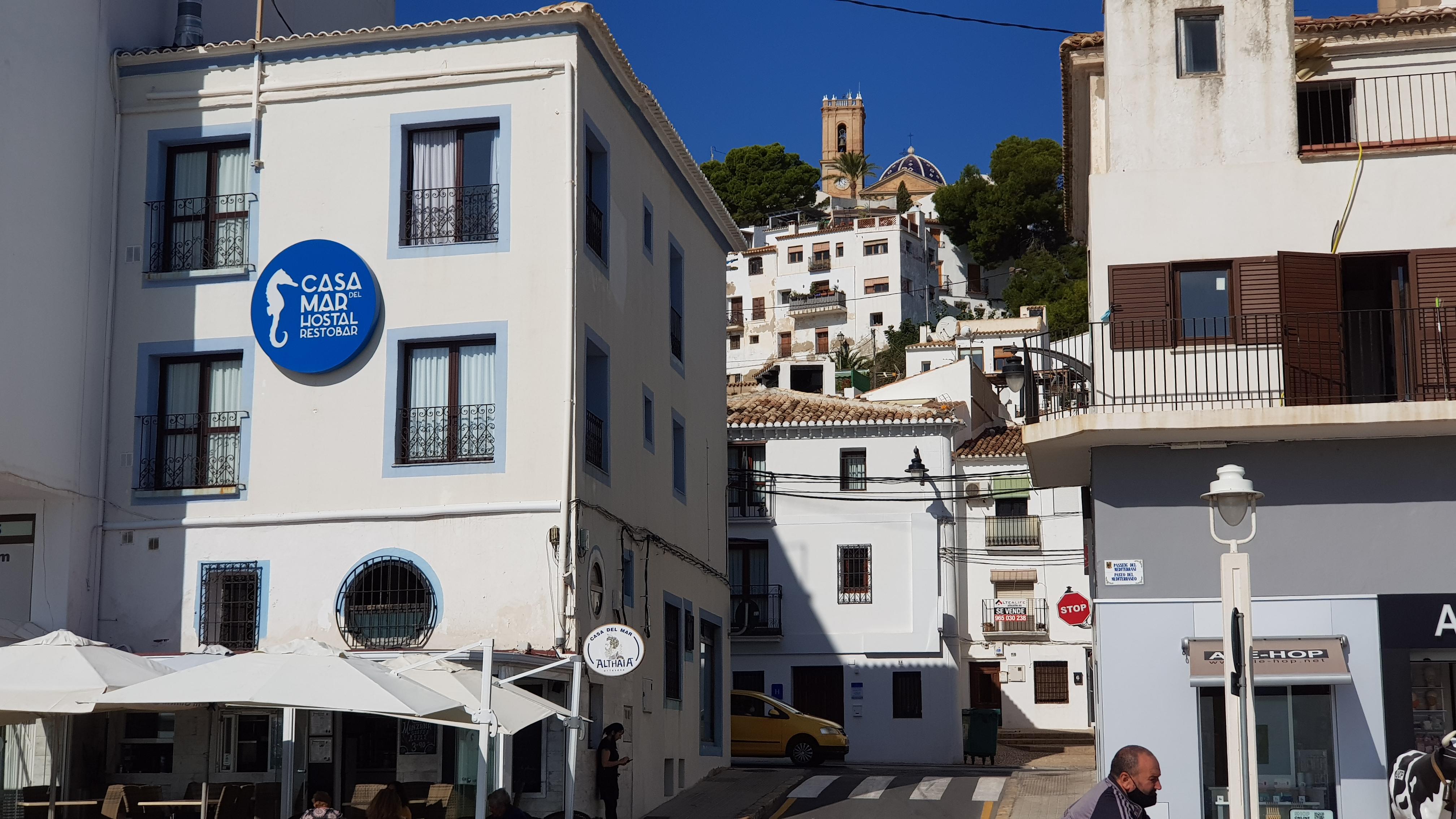 Hotel and beach front cafe with old town of Altea on hill behind with pretty church