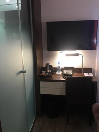 Desk area with tea and coffee and bottled water and satellite TV with six English channels