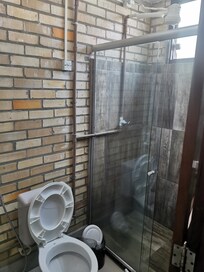 Os conduítes da parte elétrica e hidráulica ficam expostos. O chuveiro elétrico – estava com algum problema porque a água estava temperatura ambiente.