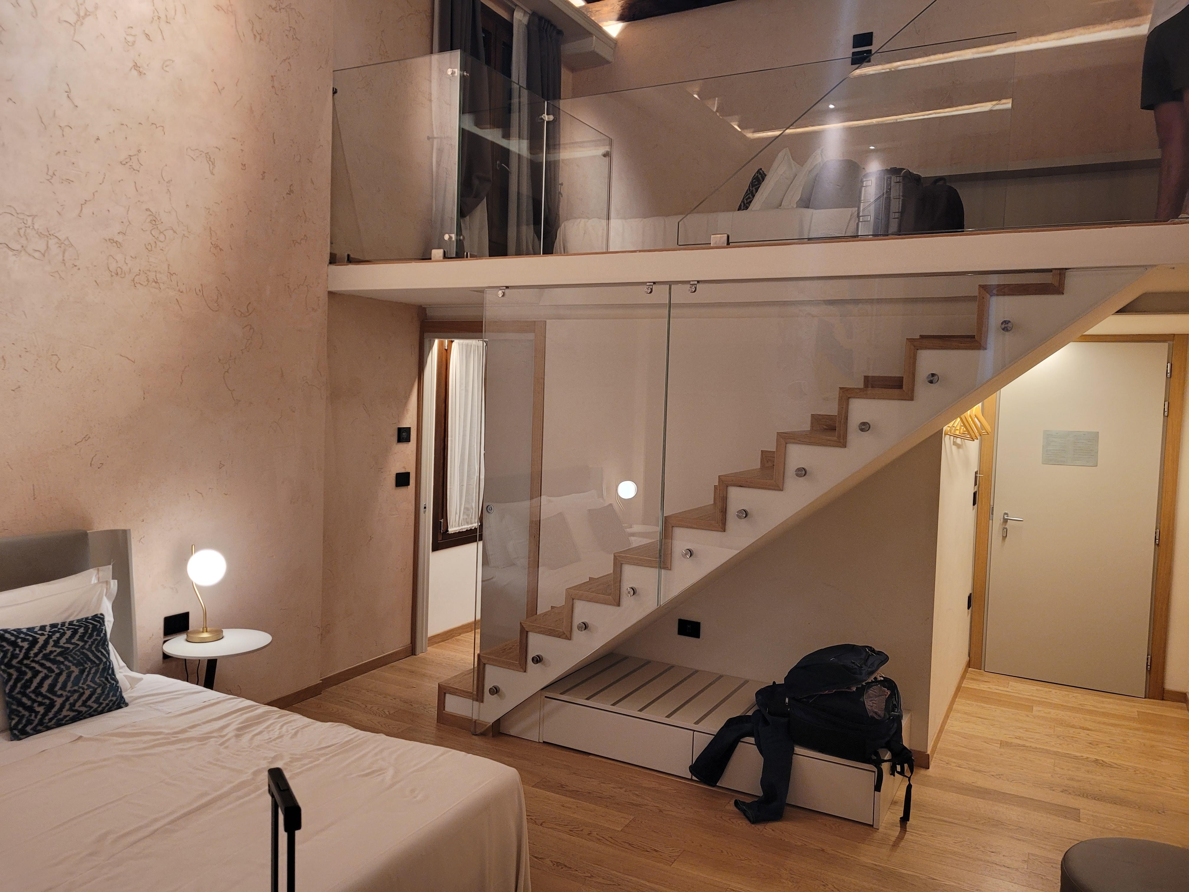 Room with bed on first floor and bed in loft.