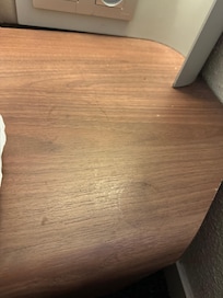 Poussière et cheveux sur la tablette à côté du lit.