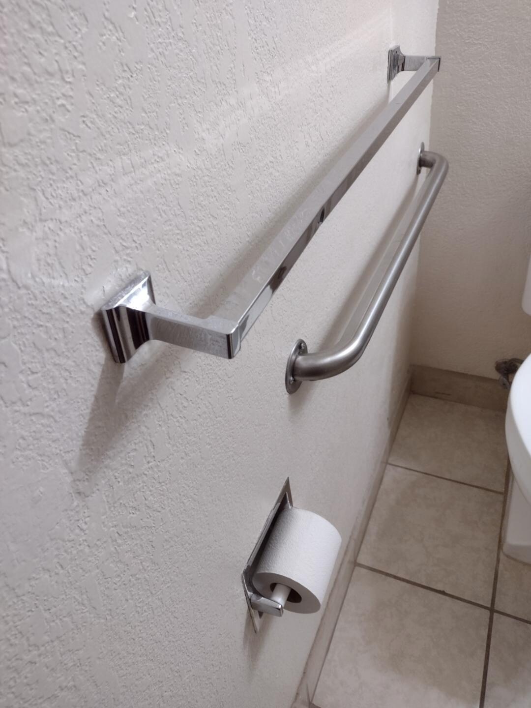Towel bar over grab bar at toilet, towel bar pulling out from its wall mount