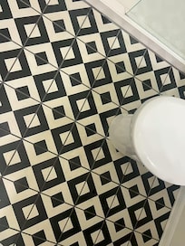 Dirty bathroom floor with visible spots and marks