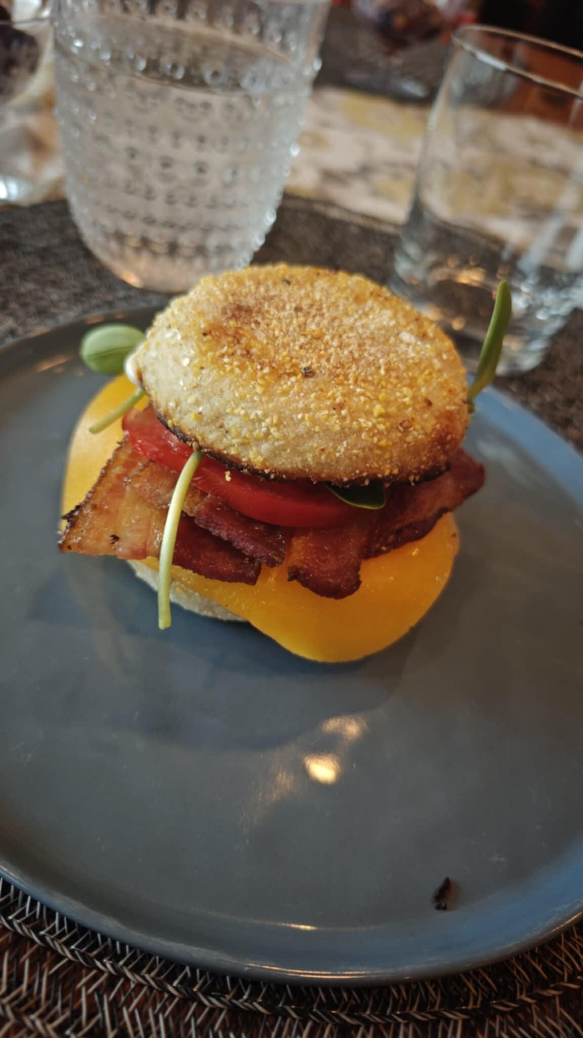 Egg, bacon, tomato English muffin sandwich.